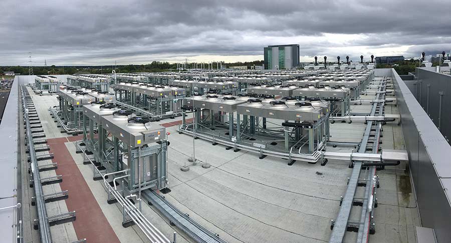 Rooftop of a large data center packed with rows of cooling units and mechanical equipment on a single-ply membrane roof