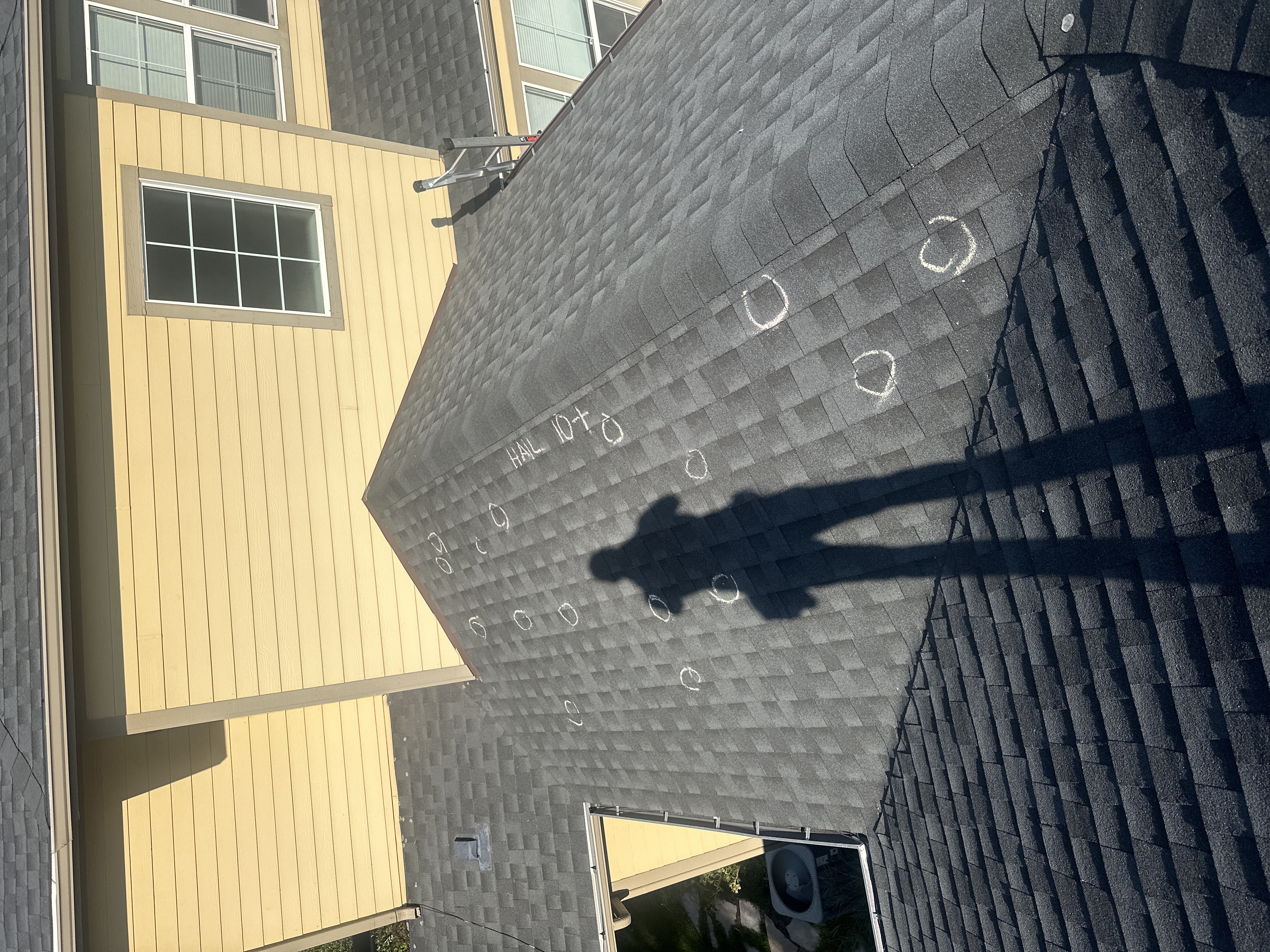 Force 5 Roofing inspector standing on a Denver Metro roof with hail strikes circled in chalk and a hit count noted — real documentation from a free inspection