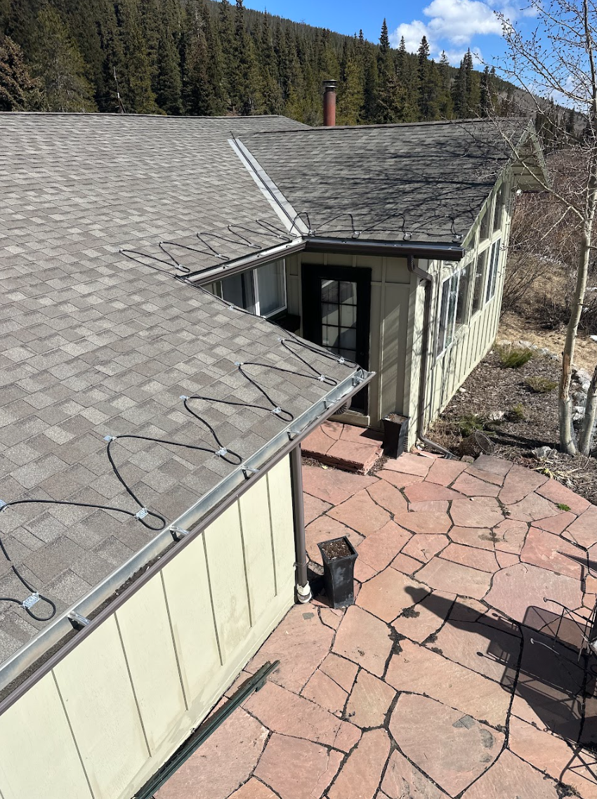 Force 5 Roofing zigzag heat cable installation along the eaves of a mountain home roof